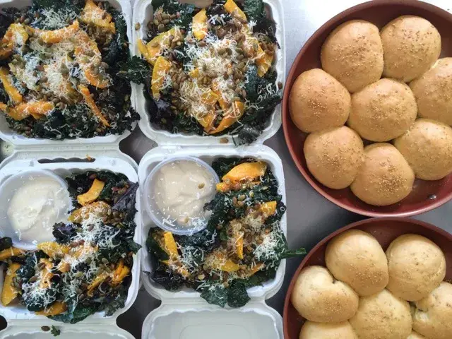 Prepared portions of greens and baked bites in serving containers.